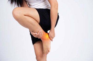 Young woman put his hand on his ankle. He has pain. Concept of medicine, massage, physiotherapy.