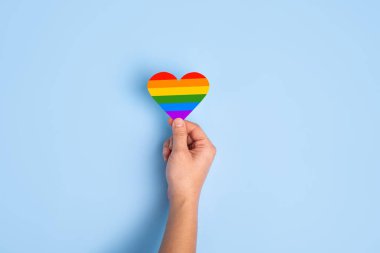 LGBTQ hakları kavramı, Gökkuşağı Kalbi mavi arka planda el şeklinde.