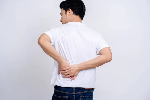 Back view of young man holding his back. He has back pain on a white background.