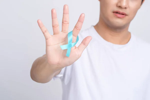 Prostate Cancer Recognition. Close-up of human hand holding blue ribbon light to support life and illness. World Men\'s Health and Cancer Day Concept