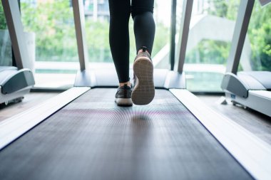 Bir koşu bandı üzerinde çalışan insanlar.