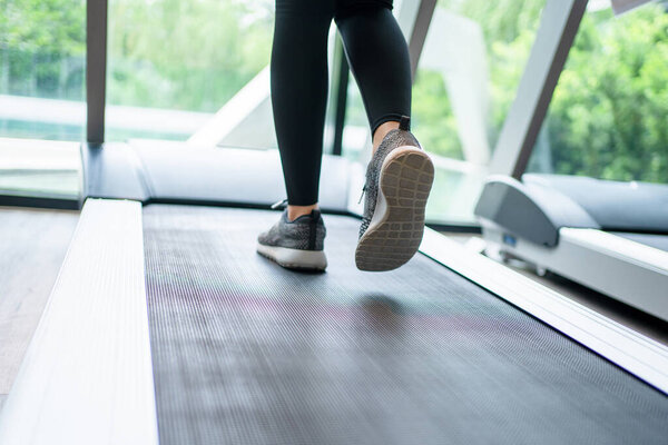 Close-up of runner's feet on a treadmill in a gym.