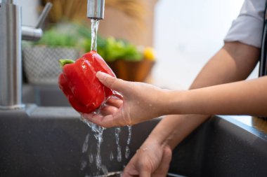 Washing vegetables. A woman in the kitchen.