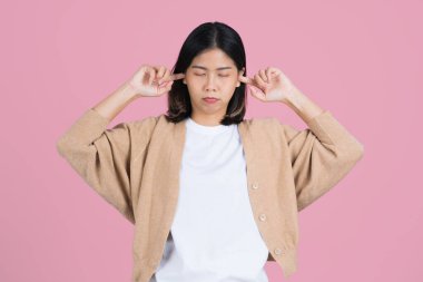 Asian woman standing isolated pink background She doesn't want to hear