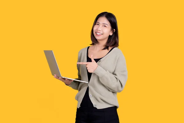 Šťastná Usměvavá Asiatka Ukazující Přenosný Počítač Ruce Izolované Žlutém Pozadí — Stock fotografie