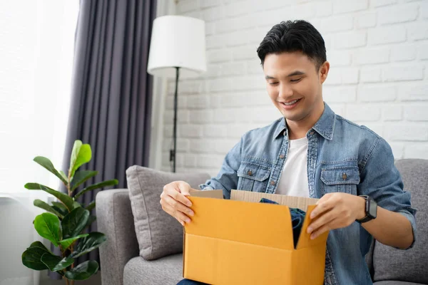 Joven Hombre Asiático Desembalaje Recibido Paquete Sienta Sofá Casa Satisfecho — Foto de Stock