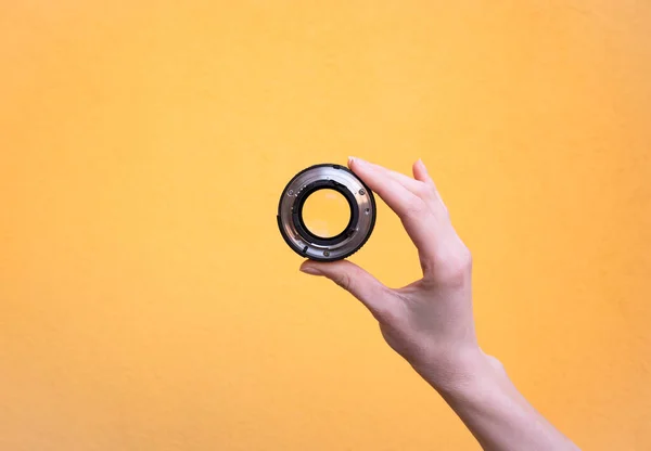 Hand holds a photographic lens — Stock Photo, Image