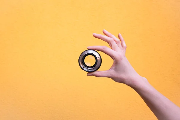 Hand holds a photographic lens — Stock Photo, Image