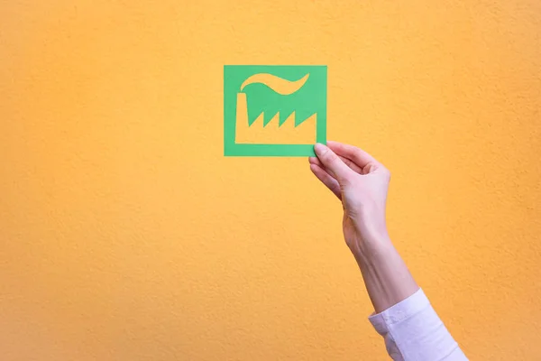 Hand holds green industry symbol — Stock Photo, Image