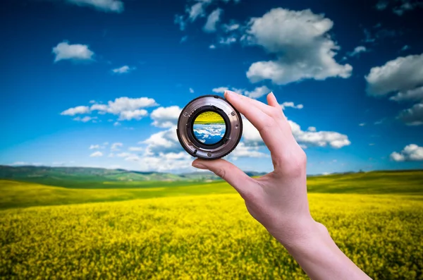 Hand holds lens viewfinder against nature in Tuscany — Stock Photo, Image
