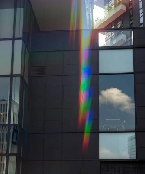 Detail of modern architecture in the city with windows on cafe and rainbow light flare.
