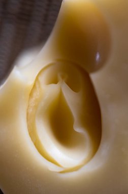 Emmental yellow cheese hole detail close up.