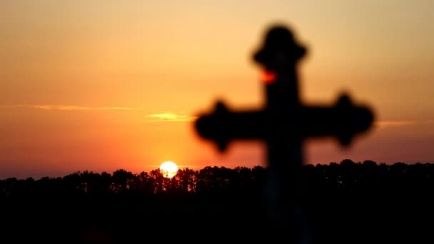 Ein Kreuz in einem Sonnenuntergang — Stockvideo