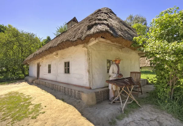 Gusli player at the house in the village of Pirogovo