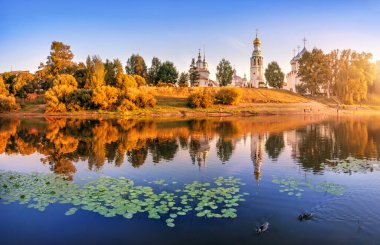 Kremlin tapınakları, nilüferler ve ördekler Vologda 'da bir yaz akşamının ışığında nehirde