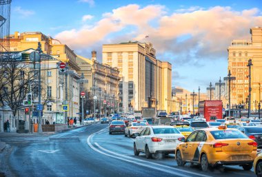 The building of the State Duma with a flag in Moscow and a traffic jam from cars