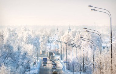 The road and trees in white snow frost in the Moscow region on a winter sunny evening. Inscription: river Klyazma