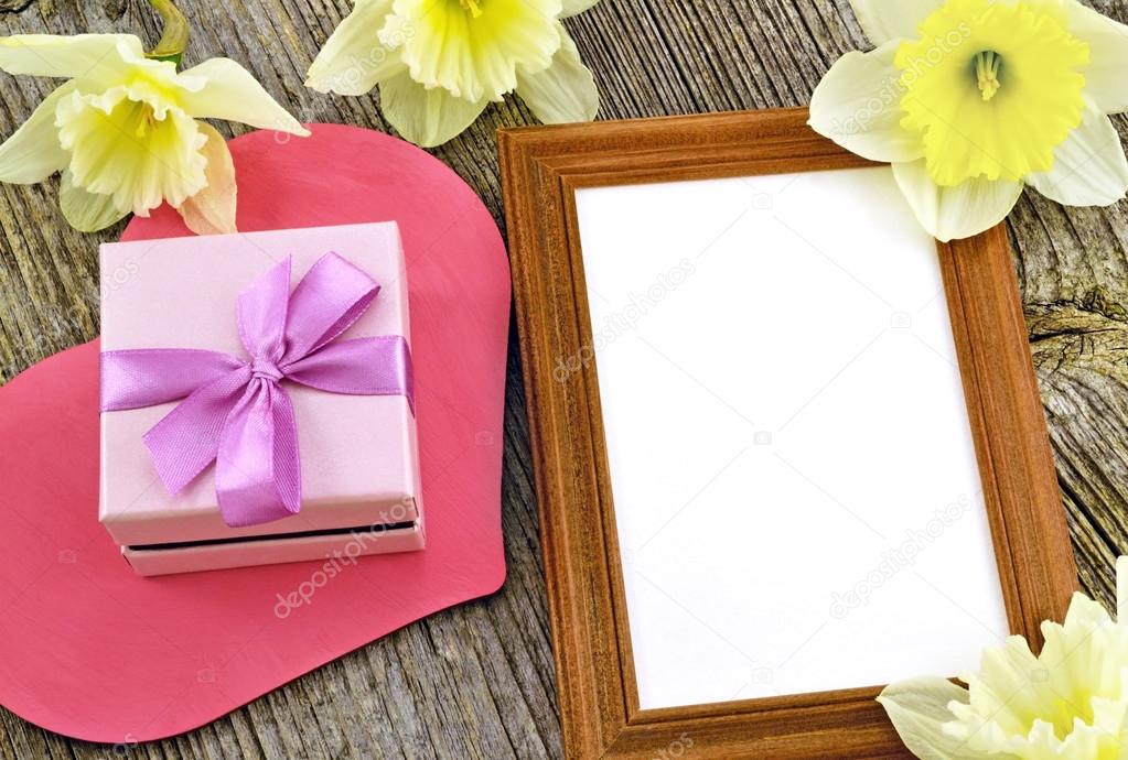 Gift box with photo frame on the background of wooden board