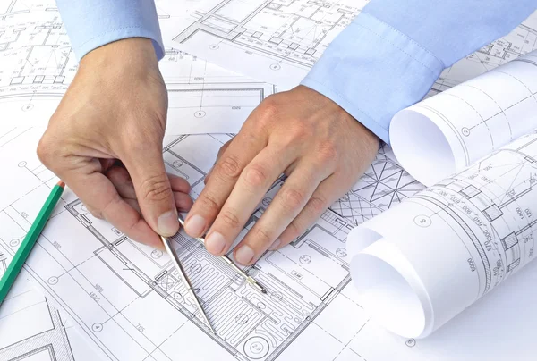 Hands with tool and project drawings — Stock Photo, Image