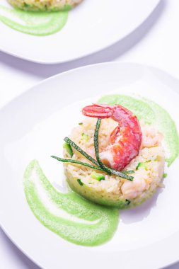 Karides ve kabak pilavı restoranda servis edilmeye hazır beyaz arka planda parlak ışıklar dikey çekimle fotoğraflandı.