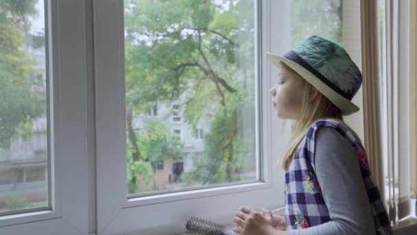 Uttråkad Flicka Tittar Genom Fönstret Från Sitt Hus — Stockvideo