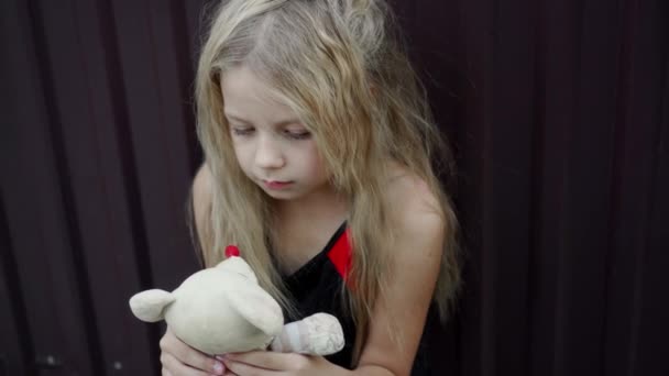 彼女の手の中に単純なおもちゃで不幸な不器用な女の子の顔に表情 発見された髪と子供の悲しい表情 — ストック動画