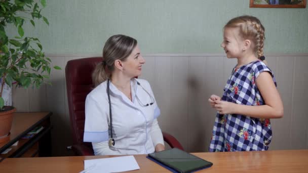 一位妇女 一位儿科医生 检查一位女病人 她分析了一下这个女孩的健康状况 和蔼可亲地和她说话 — 图库视频影像
