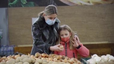 Anne ve kızı ürünleri süpermarkette ya da markette seçiyorlar. Çocukların ebeveynler tarafından eğitimi.