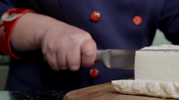 Ženská ruka krájí sýr nožem. — Stock video