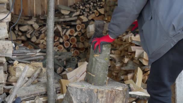 Un hombre en el pueblo está cortando madera.. — Vídeos de Stock