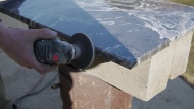 Usta bir taşla öğütücü kullanarak çalışıyor. Seviyeyi düzleştirir. Yakın plan..