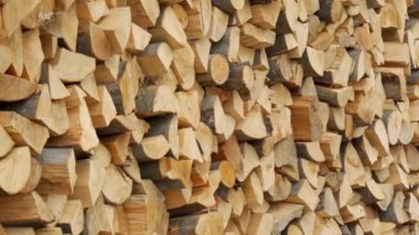 Yığılmış odunların dokusu. Yakacak odunları ısıtmaya hazırlanıyorum. Kameranın düzgün istiflenmiş odun sıraları boyunca yavaşça hareket etmesi..