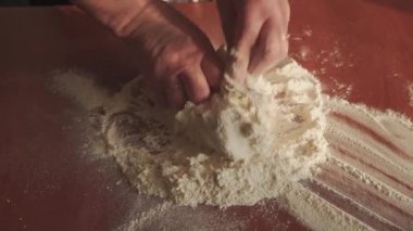 Sabahın erken saatlerinde, dişi eller hamuru ahşap bir masada yoğurur. Evde ekmek yapıyorum. Yukarıdan görüntüle.