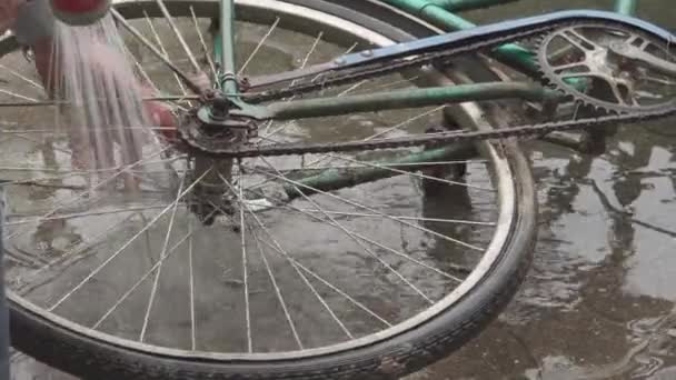 古い汚れた自転車の車輪は水のジェットで洗われている 田舎の交通機関 — ストック動画