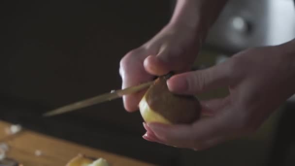 女人的手在做饭 马铃薯剥皮和切碎 用于烹调 黑暗背景 有选择的重点 — 图库视频影像