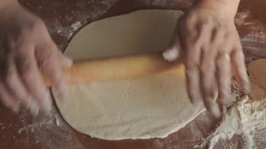 Kadın eli, merdane kullanarak hamuru fırına verir. Kırsalda ev yapımı basit bir mutfak. Kendi ekmeğinizi ya da kurabiyelerinizi yapmak.