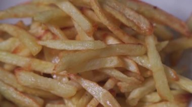 Place the cooked french fries on a plate. Close-up.