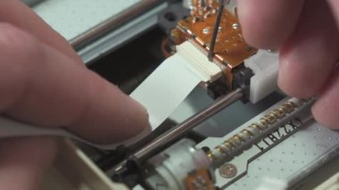 Bir elektronik tamircisinin işi. Döngü kablosunu dijital karttan ayır. Yakın plan..