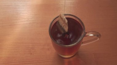 Çay demlemek için cam bardağa sıcak su dök. Çay poşetini kaynar suya batır. Yukarıdan görüntüle