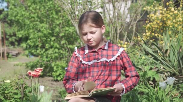 Uma Menina Idade Escolar Livro Jardim Bom Tempo Ensolarado Vegetação — Vídeo de Stock