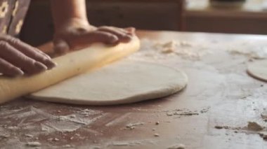 Kadın eli, merdane kullanarak hamuru fırına verir. Kırsalda ev yapımı basit bir mutfak. Kendi ekmeğinizi ya da kurabiyelerinizi yapmak.