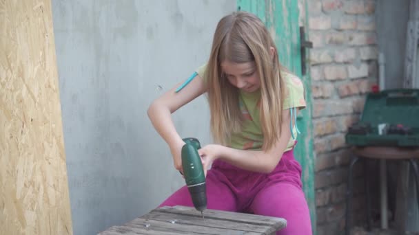 Dziewczynka Wieku Szkolnym Naprawia Stary Stołek Używa Narzędzia Budowlanego Napędzania — Wideo stockowe