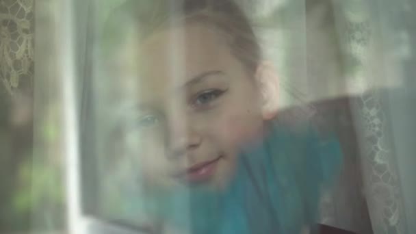一个小女孩帮助她的父母打扫公寓 她小心地擦拭着房子的窗户 — 图库视频影像