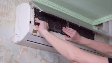 Kadınların elleri klimanın kirli hava filtresini kaldırır. 4k video.