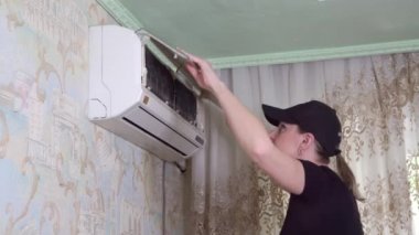 Temizlik şirketindeki kadın ev kliması servisi yapıyor. Filtrelerin durumunu inceler. 4k video