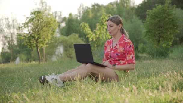 Una Mujer Mediana Edad Sienta Césped Del Parque Usando Enlace — Vídeo de stock