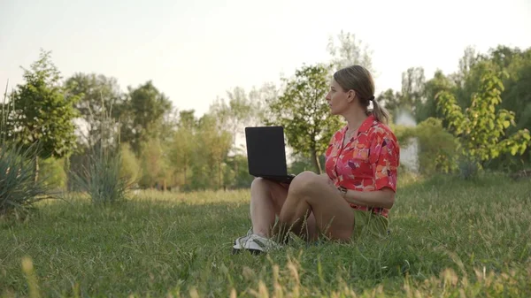 Молодая Женщина Ноутбуком Сидит Траве Парке Думает Глядя Вдаль — стоковое фото