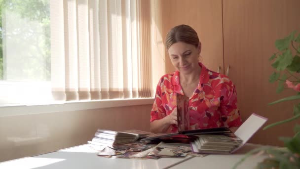 Mujer Mirando Foto Del Álbum Familiar Recuerda Incidente Divertido Sonríe — Vídeos de Stock