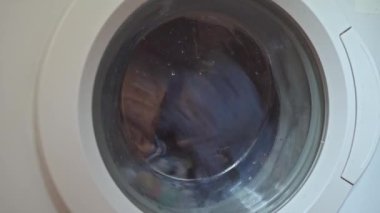 Çamaşırların döndüğü cam çamaşır makinesi kapısı. Oda servisi..