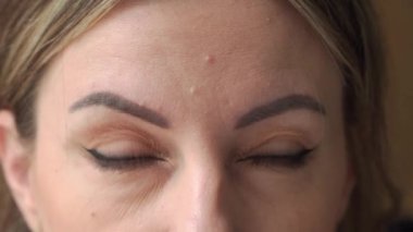 Kadın gözlerini kırpıyor. Yakın plan, gözlere odaklan..